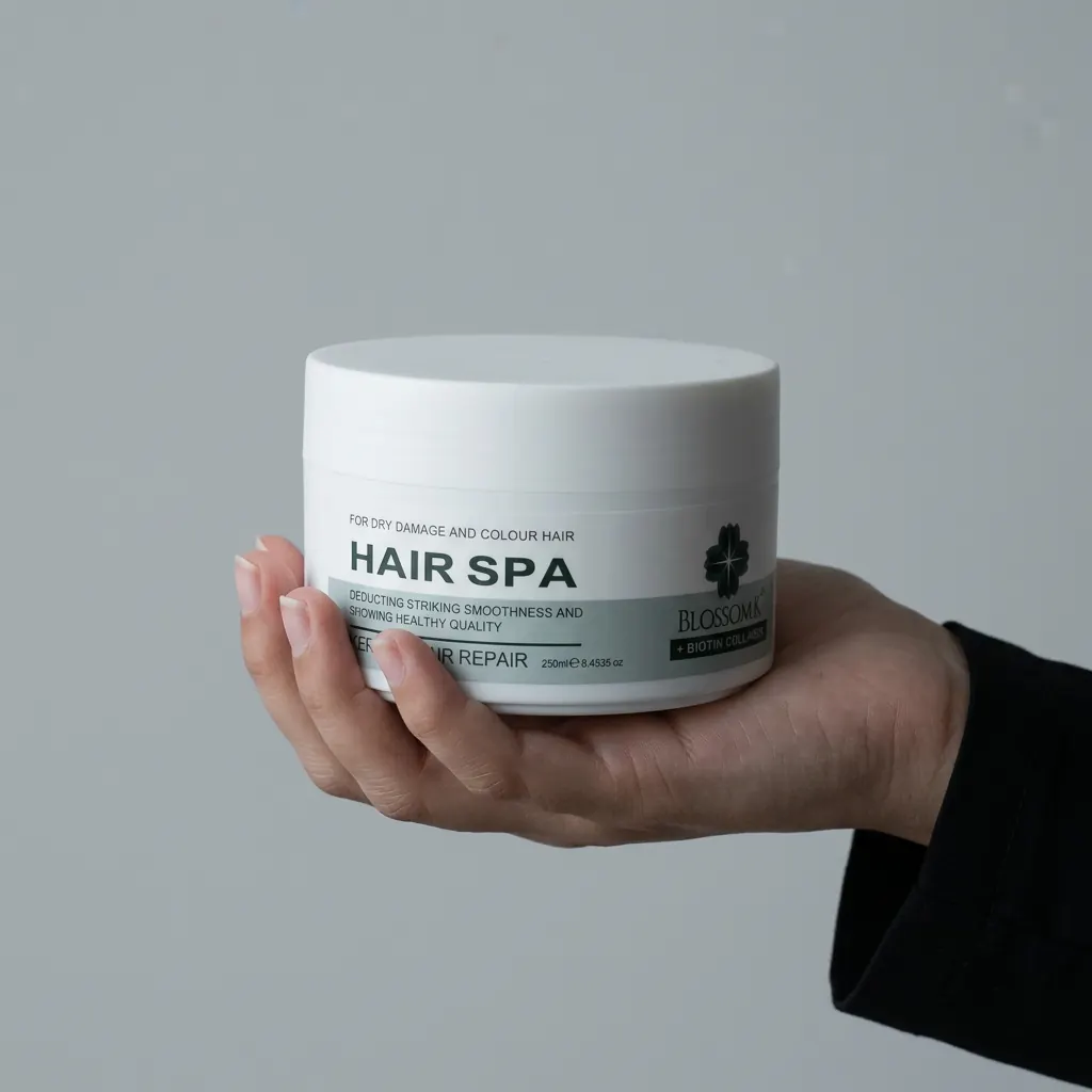 Hand holding BlossomK Hair Spa Keratin Repair Mask 250ml against a cool grey background