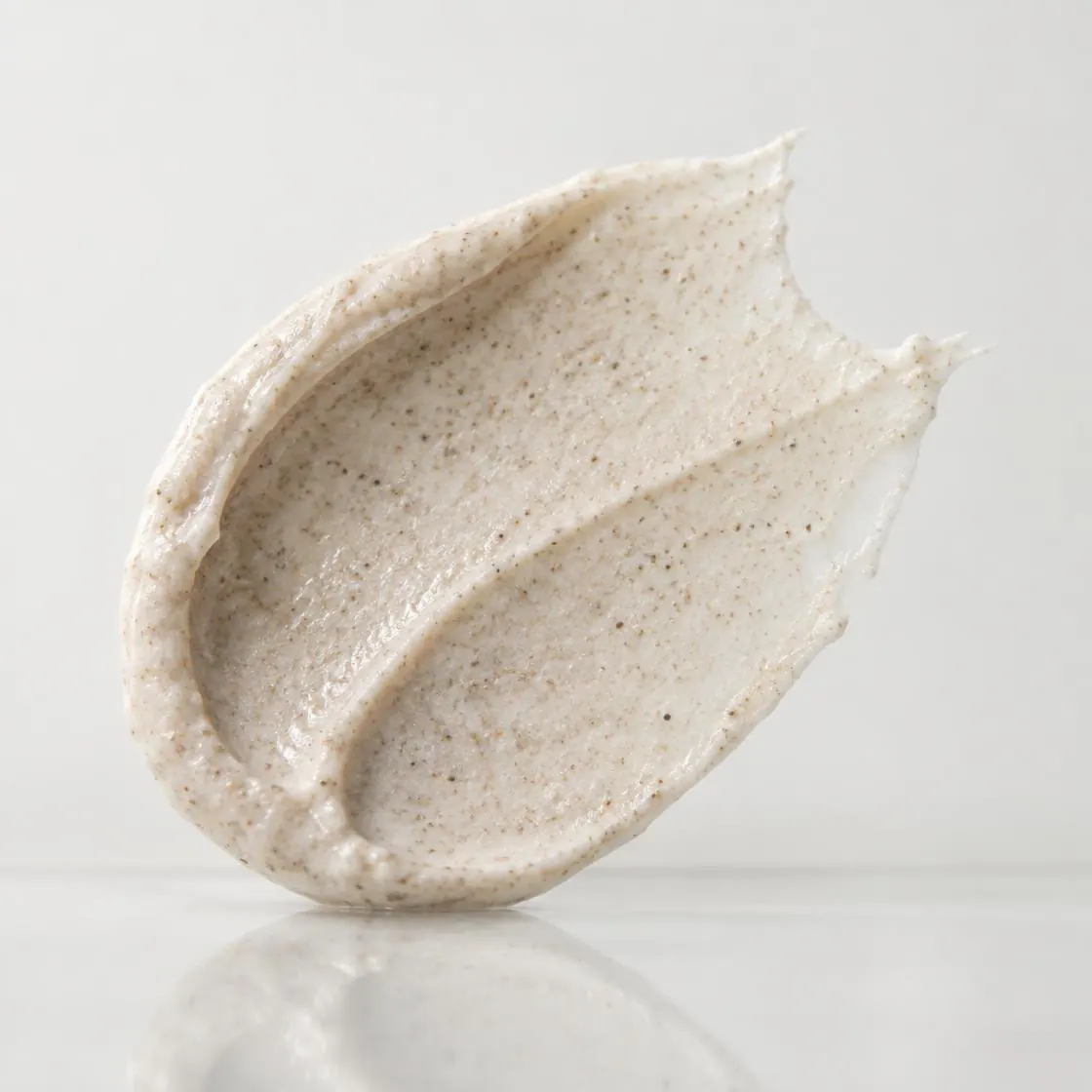 BlossomK Exfoliating Face and Body Scrub 200g formula texture on glass