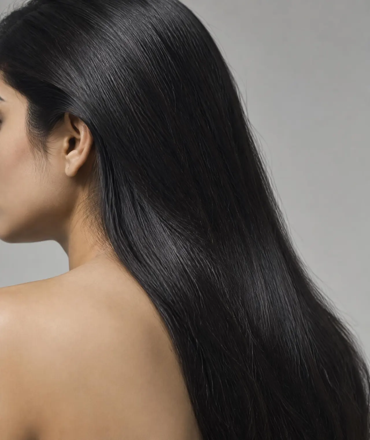South Asian woman with sleek black hair in sharp studio light