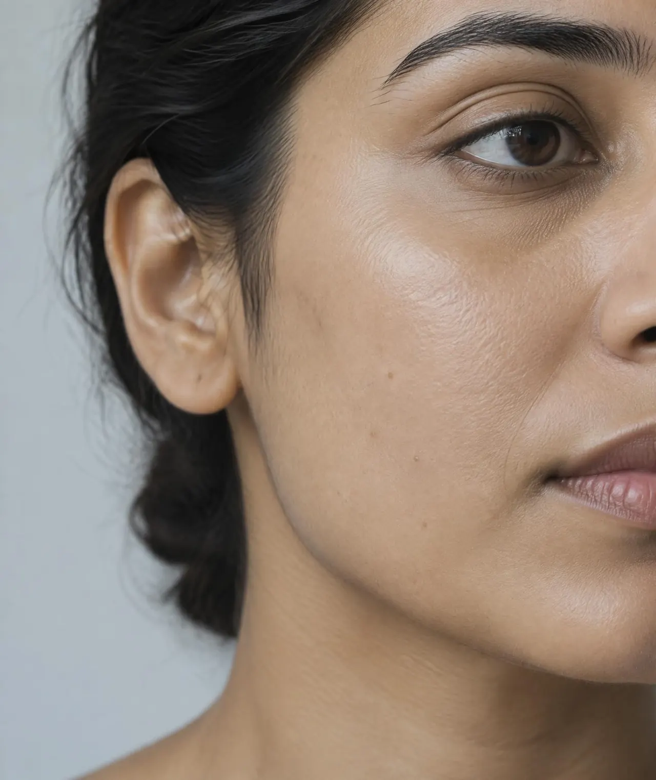 South Asian woman showing natural skin texture in sharp studio light